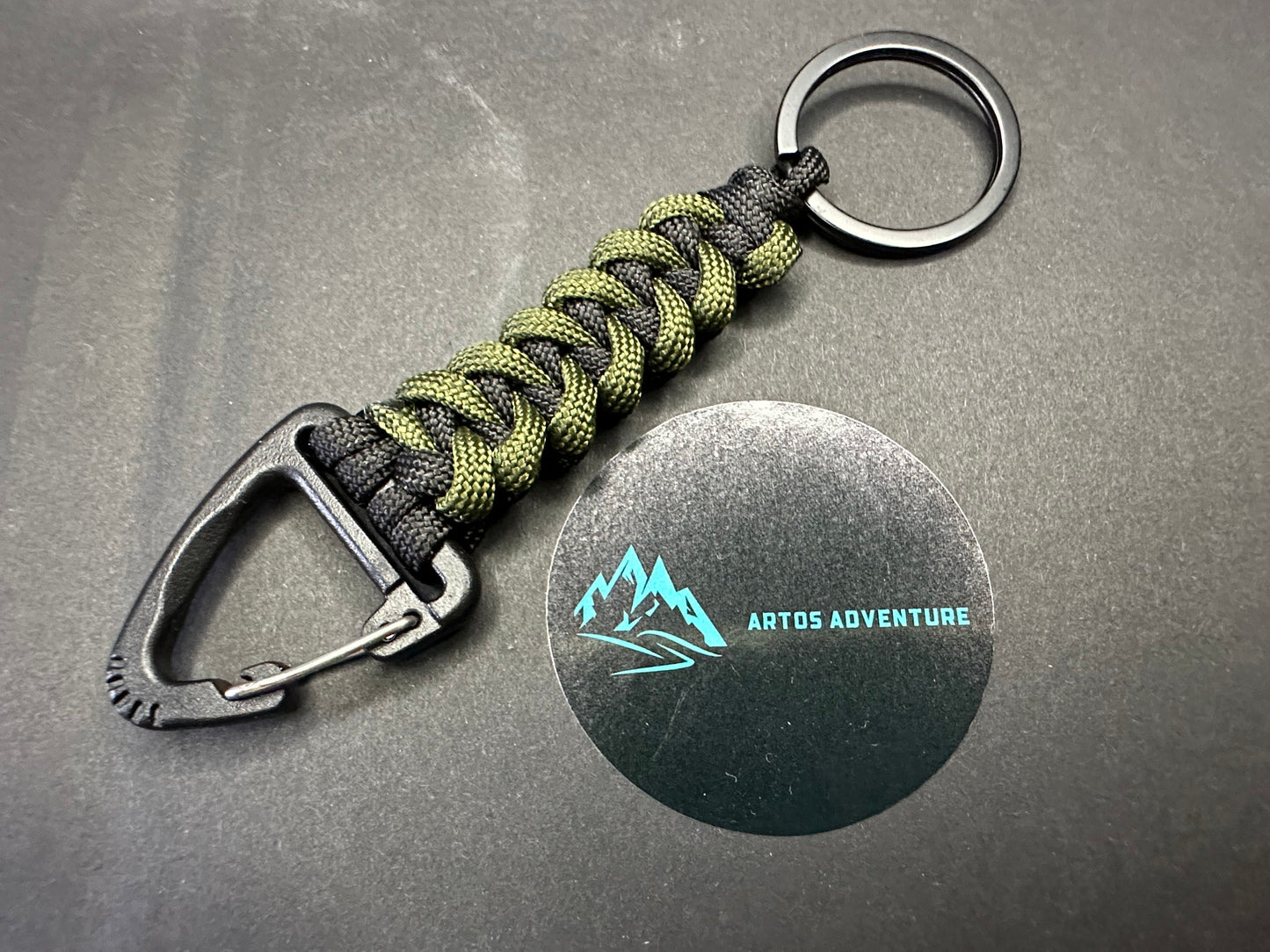Tactical EDC Paracord keyring with a triangle clip and split ring, made in Army olive Green and Black coloured shark jaw weave