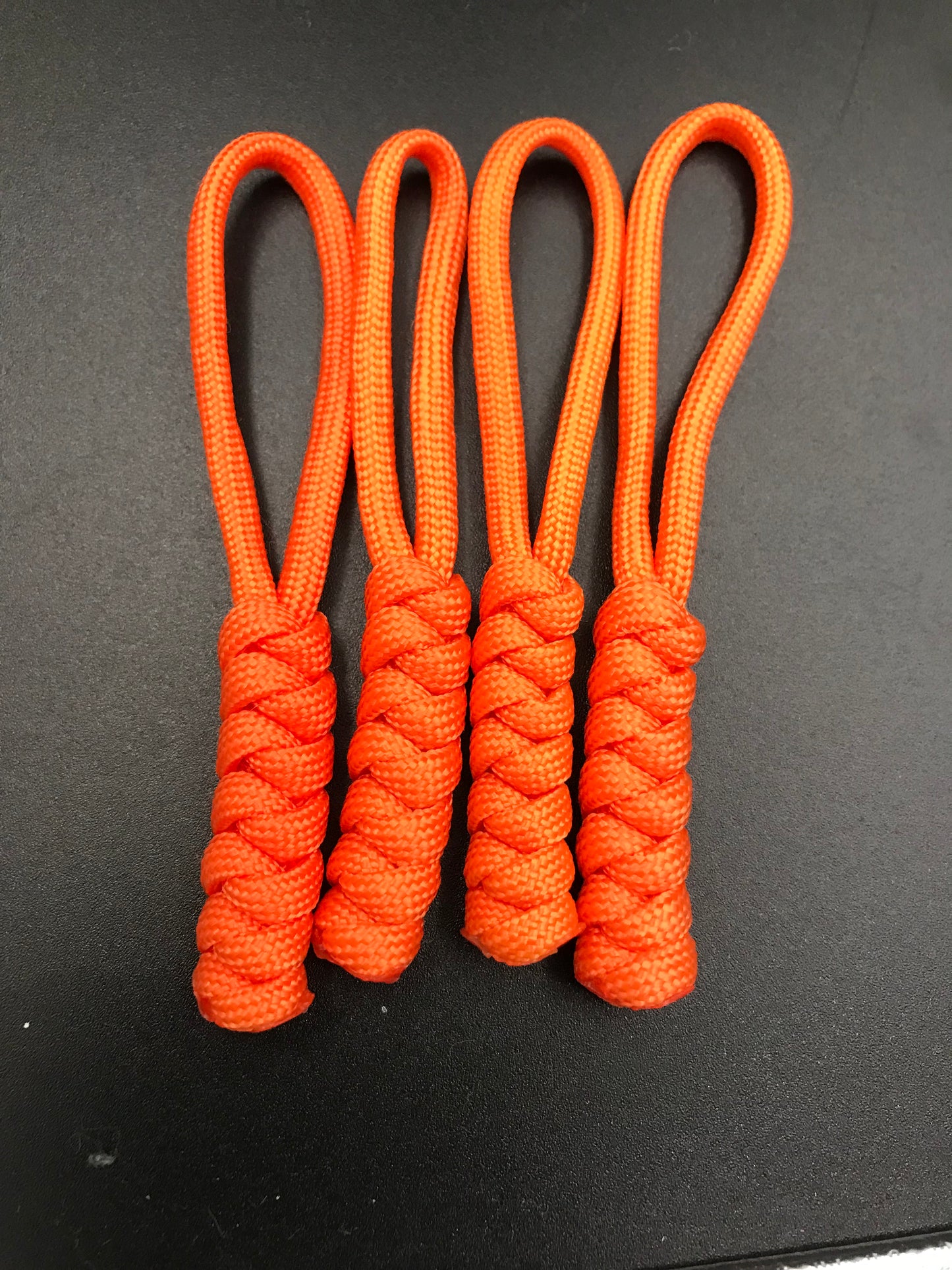 Paracord zip pulls in neon bright orange ( 4 pack) light weight and strong and handmade in U.K.