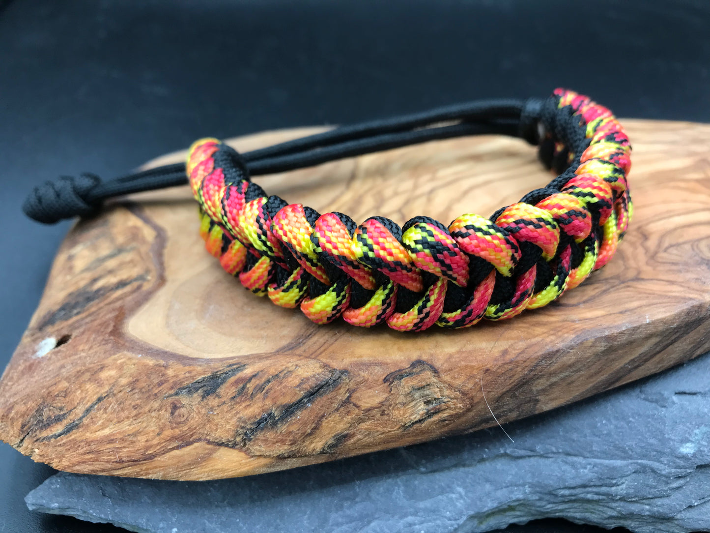 Paracord survival bracelet hand made lightweight and in black and fireball coloured Paracord