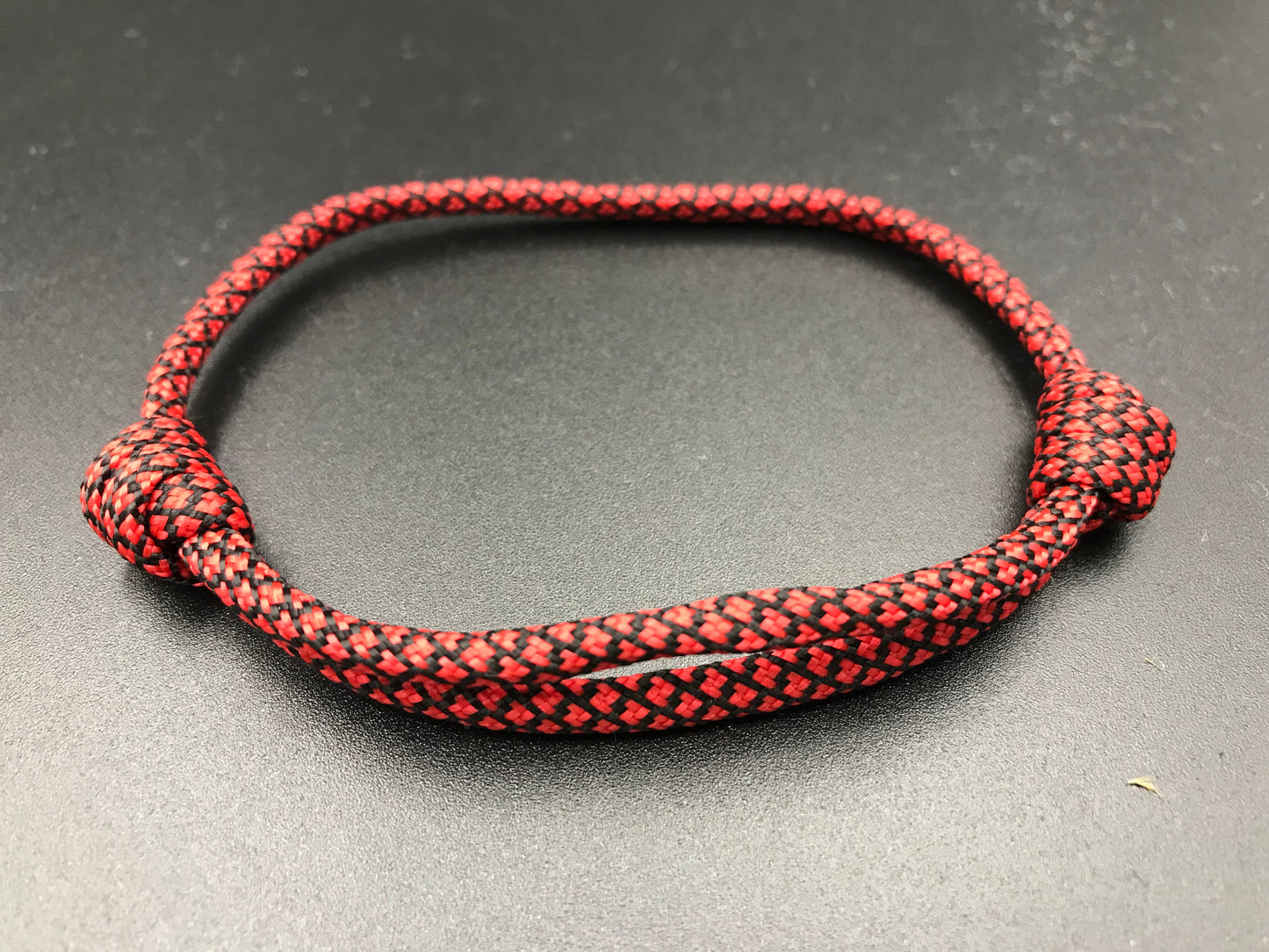 Paracord friendship bracelet in red with black diamond pattern