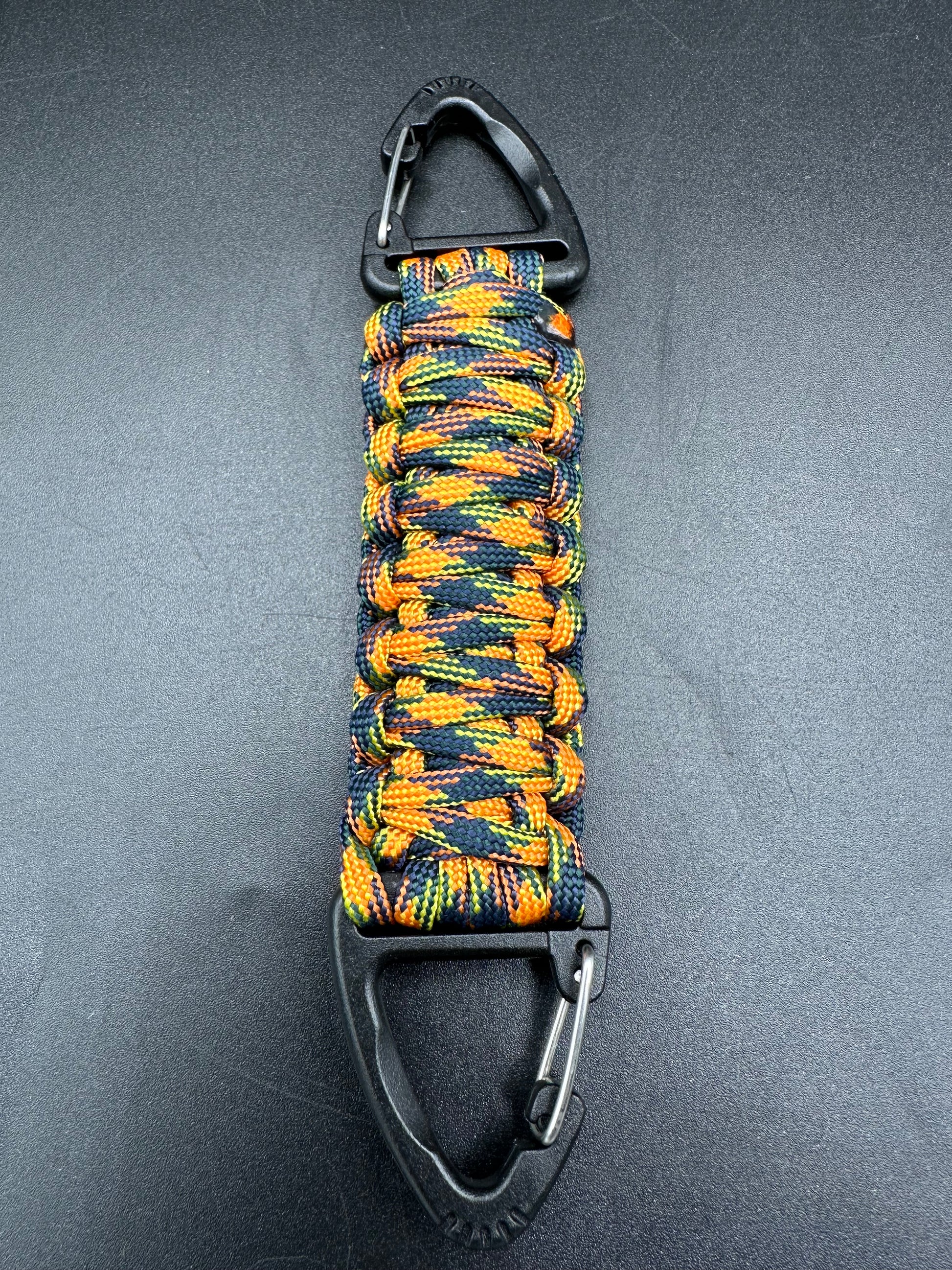 Our Tactical double ended triangle clip with a beautiful Paracord king cobra woven centre, are designed for your EDCs, molle, army bags and other field Attachments, handmade in this orange jungle camouflaged (orange black yellow) colours