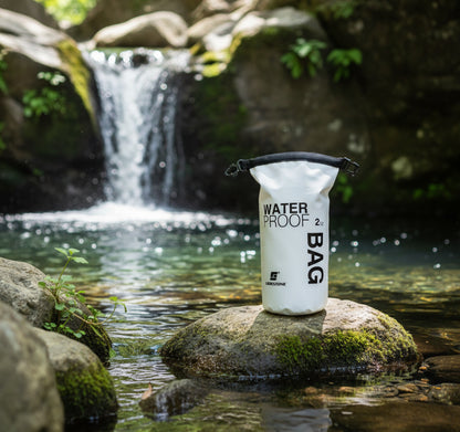 2L waterproof dry bag on rock with waterfall outdoor adventure scene