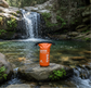2 litre dry bag waterproof storage in orange by a rock pool waterfall hiking gear