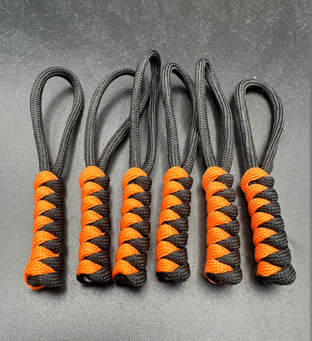 Paracord zip pulls in a Halloween themed black & bright orange 
Sold as a 6 pack theses are light weight, strong and all handmade in our U.K. store
