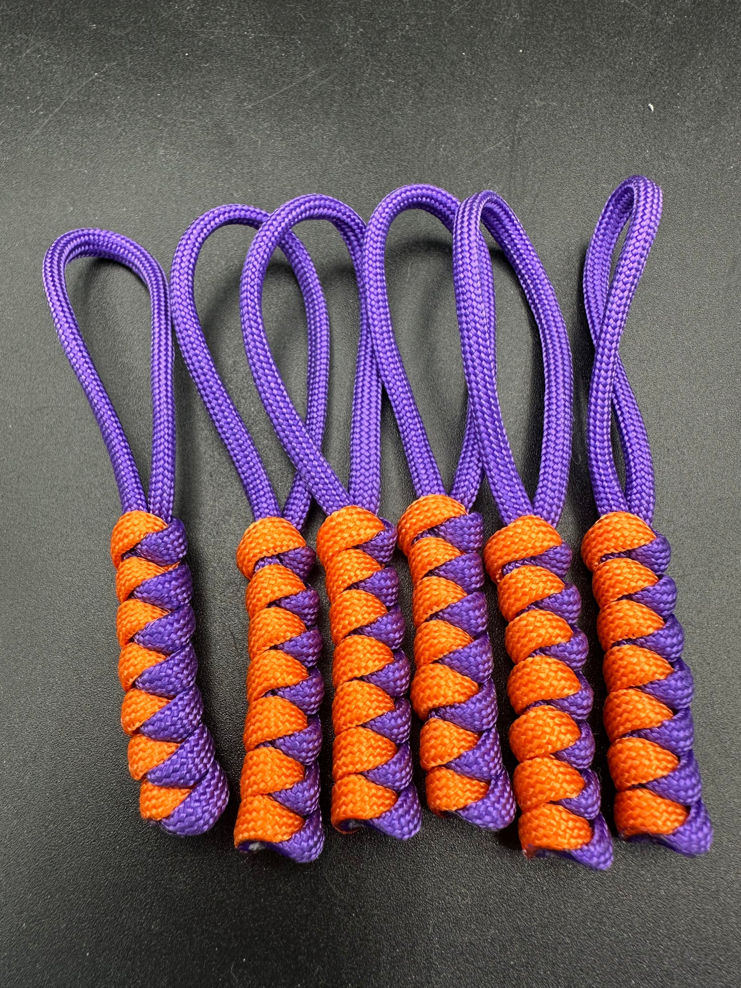 Paracord zip pulls in a Halloween themed purple and bright orange 
Sold as a 6 pack theses are light weight, strong and all handmade in our U.K. store