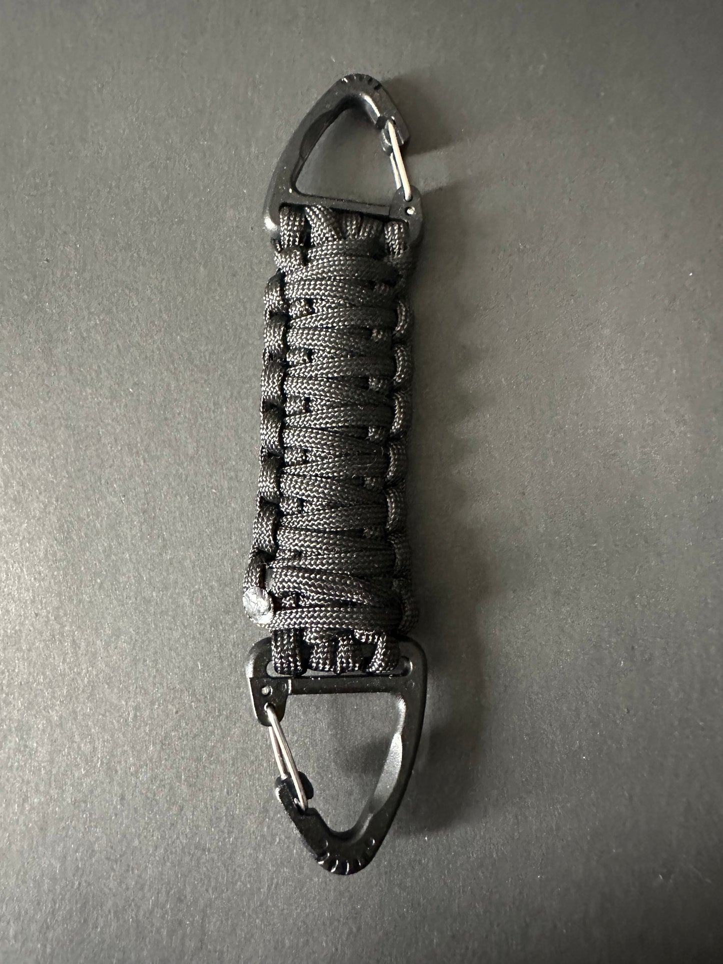 Our Tactical double ended triangle clip with a beautiful Paracord king cobra woven centre, are designed for your EDCs, molle, army bags and other field Attachments, handmade in this bold black colour