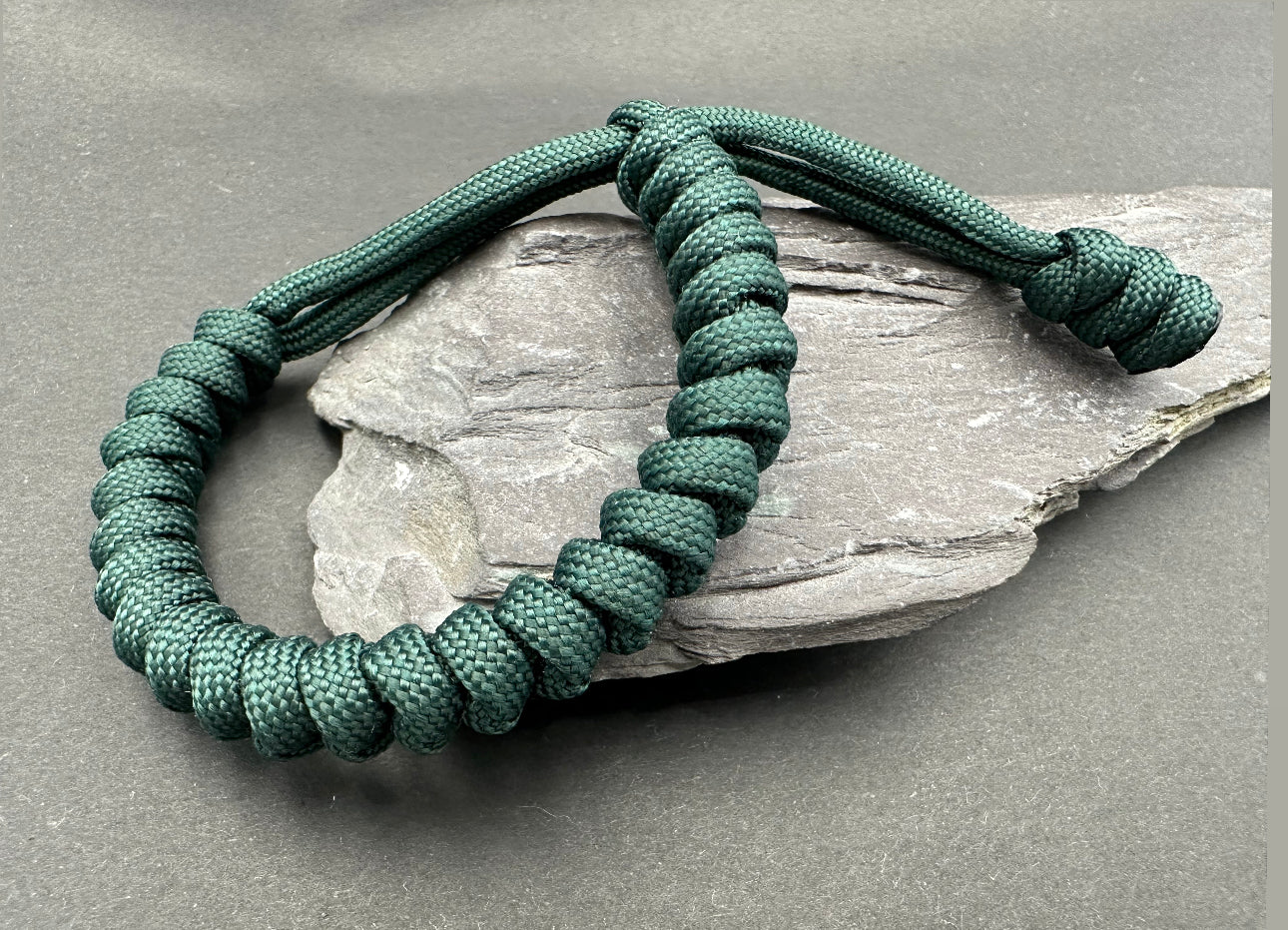 Paracord survival bracelets in an Emerald green colour. the item is lightweight comfortable and handmade in a snake knott tactical design U.K.