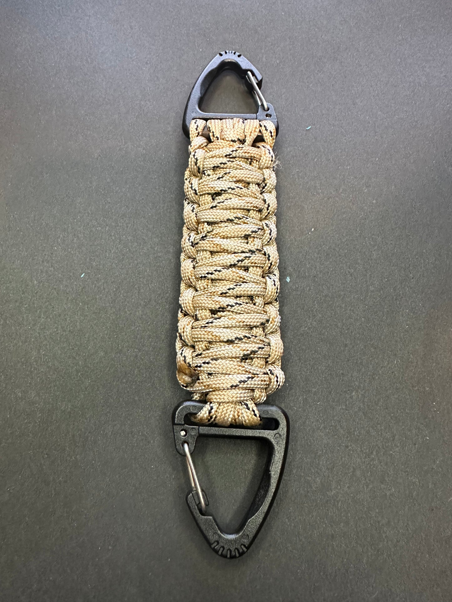 Our Tactical double ended triangle clip with a beautiful Paracord king cobra woven centre, are designed for your EDCs, molle, army bags and other field Attachments, handmade in this Desert camouflaged colour