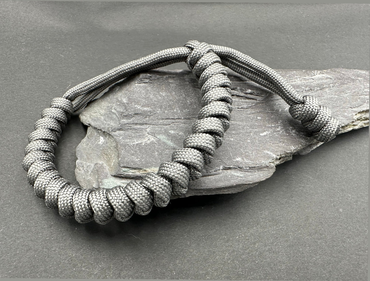 Paracord survival bracelets in an anthracite grey colour, the item is lightweight comfortable and handmade in a snake knott tactical design U.K.