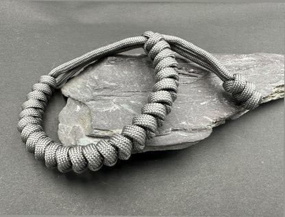 Paracord survival bracelets in an anthracite grey colour, the item is lightweight comfortable and handmade in a snake knott tactical design U.K.