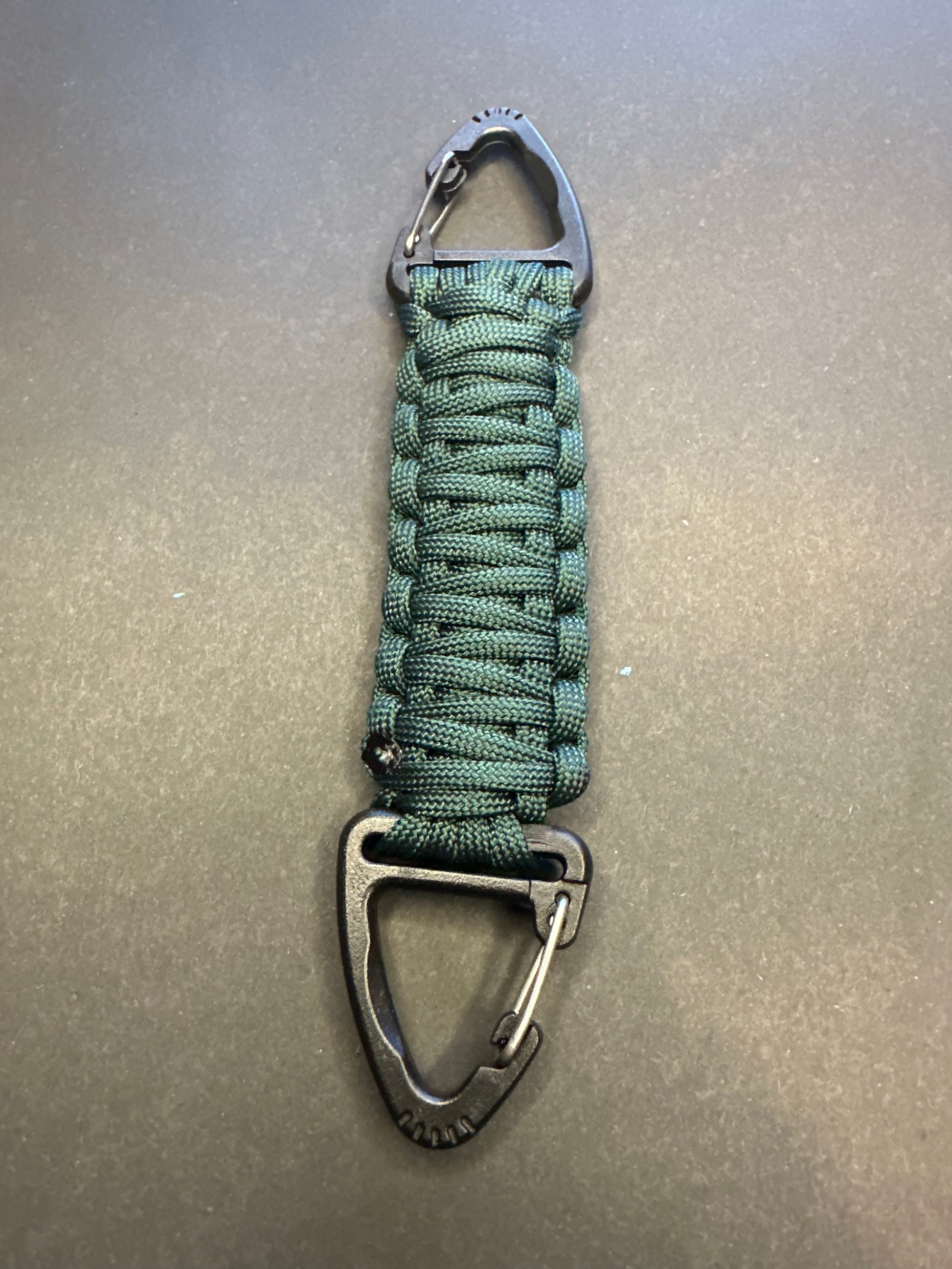 Our Tactical double ended triangle clip with a beautiful Paracord king cobra woven centre, are designed for your EDCs, molle, army bags and other field Attachments, handmade in this Emerald Green colour