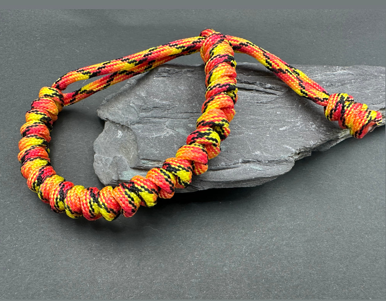 Paracord survival bracelets in the Fireball colour, (red yellow orange mix) the item is lightweight comfortable and handmade in a snake knott tactical design U.K.
