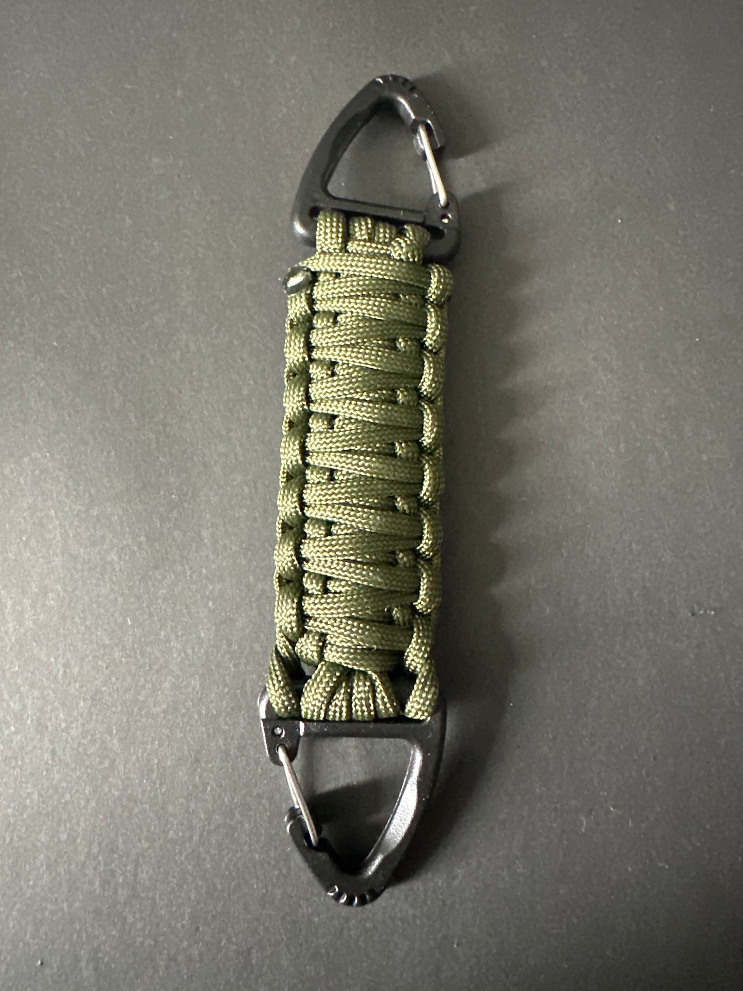 Our Tactical double ended triangle clip with a beautiful Paracord king cobra woven centre, are designed for your EDCs, molle, army bags and other field Attachments, handmade in this army olive green colour