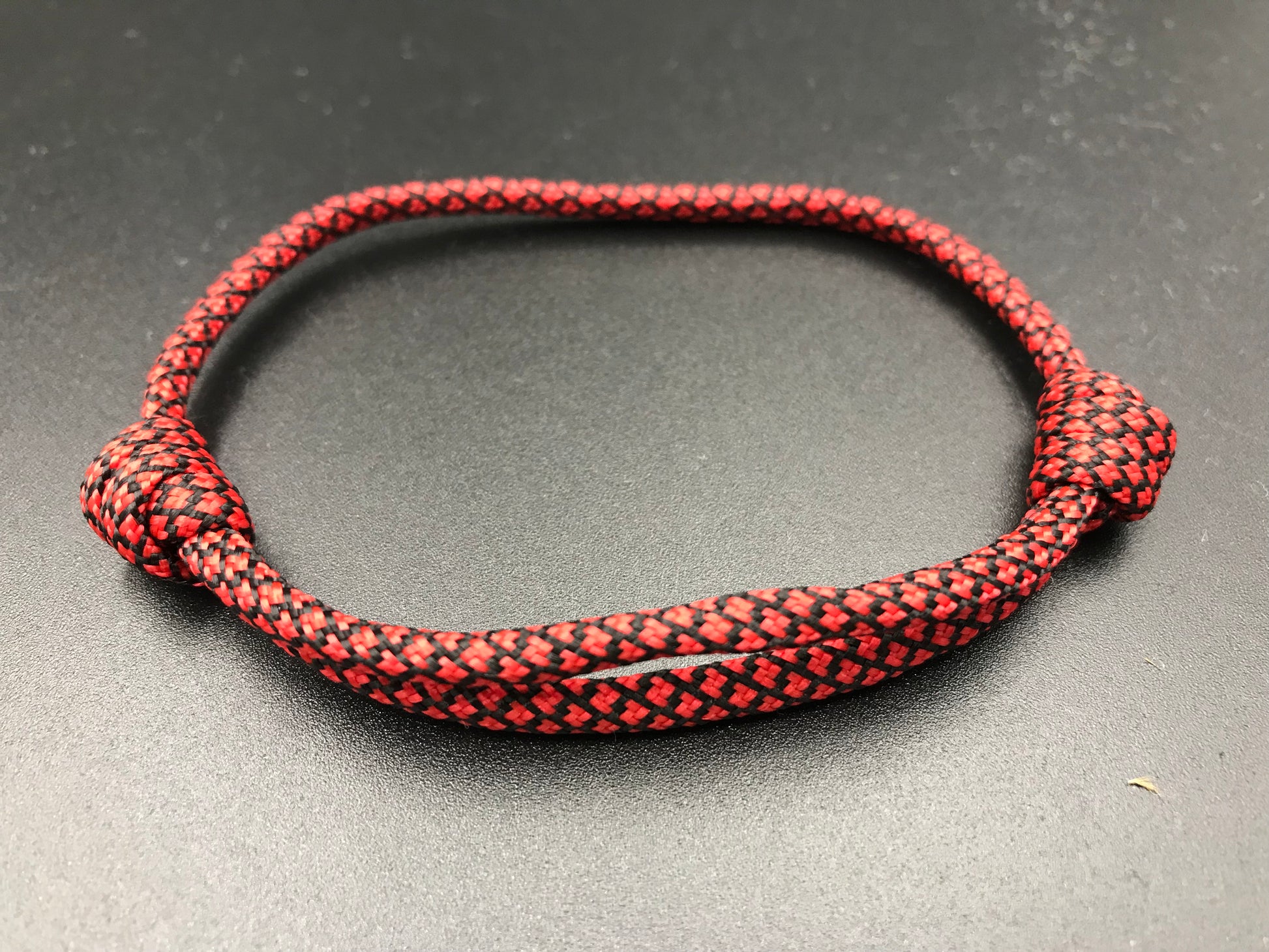 Paracord friendship bracelet in red with black diamond pattern 