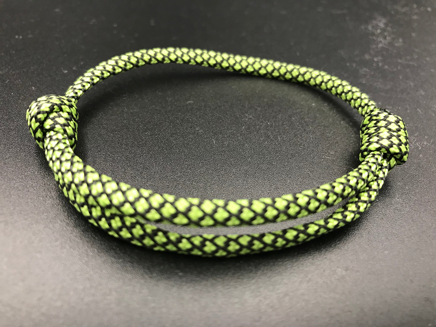 Paracord friendship bracelet in light green with a black diamond pattern light weight and adjustable 