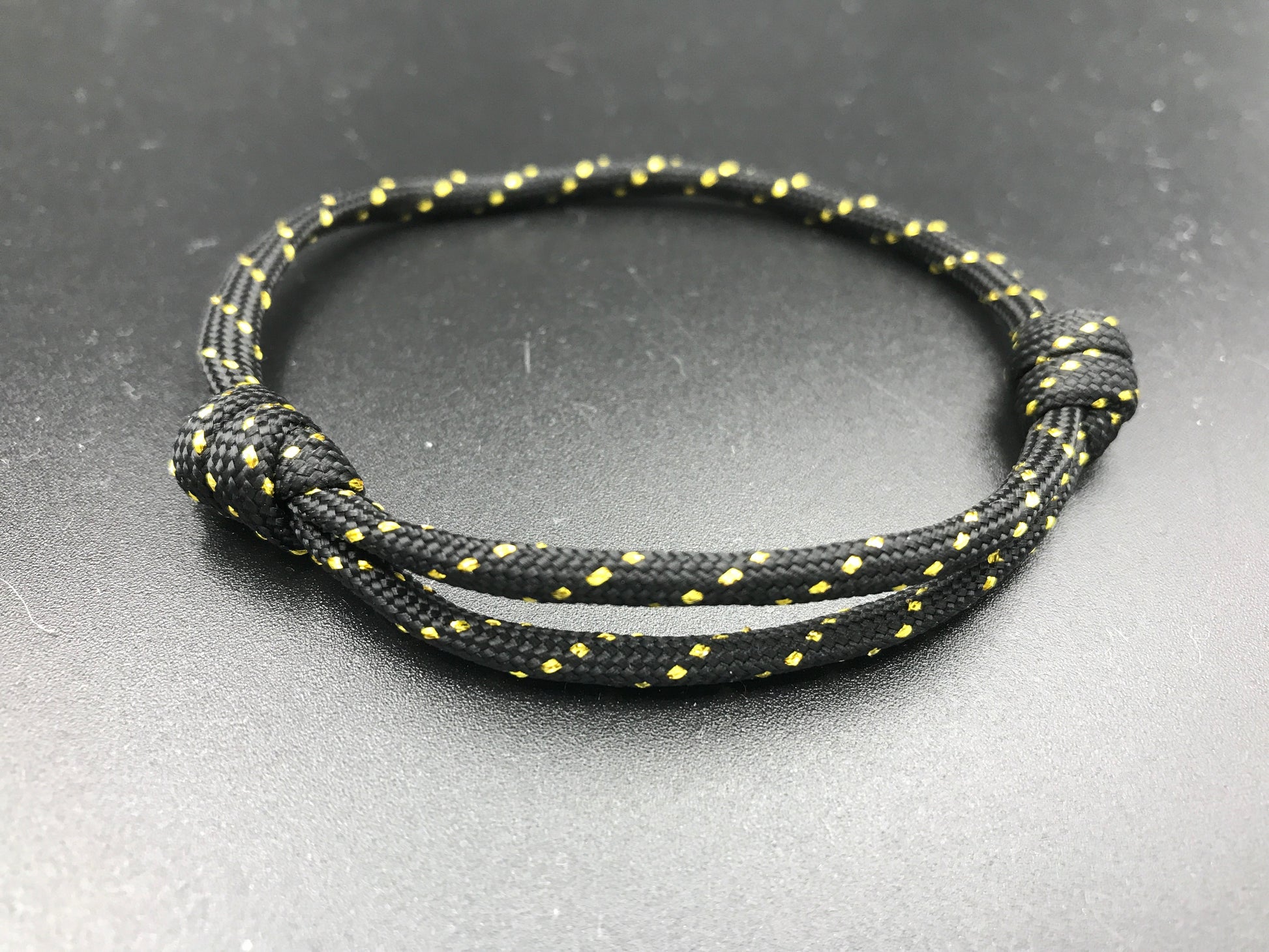 Paracord friendship bracelet in black and gold flecks lightweight and adjustable